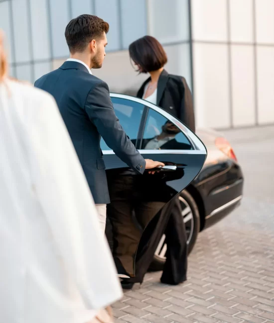 business-couple-on-parking-lot-near-luxury-car